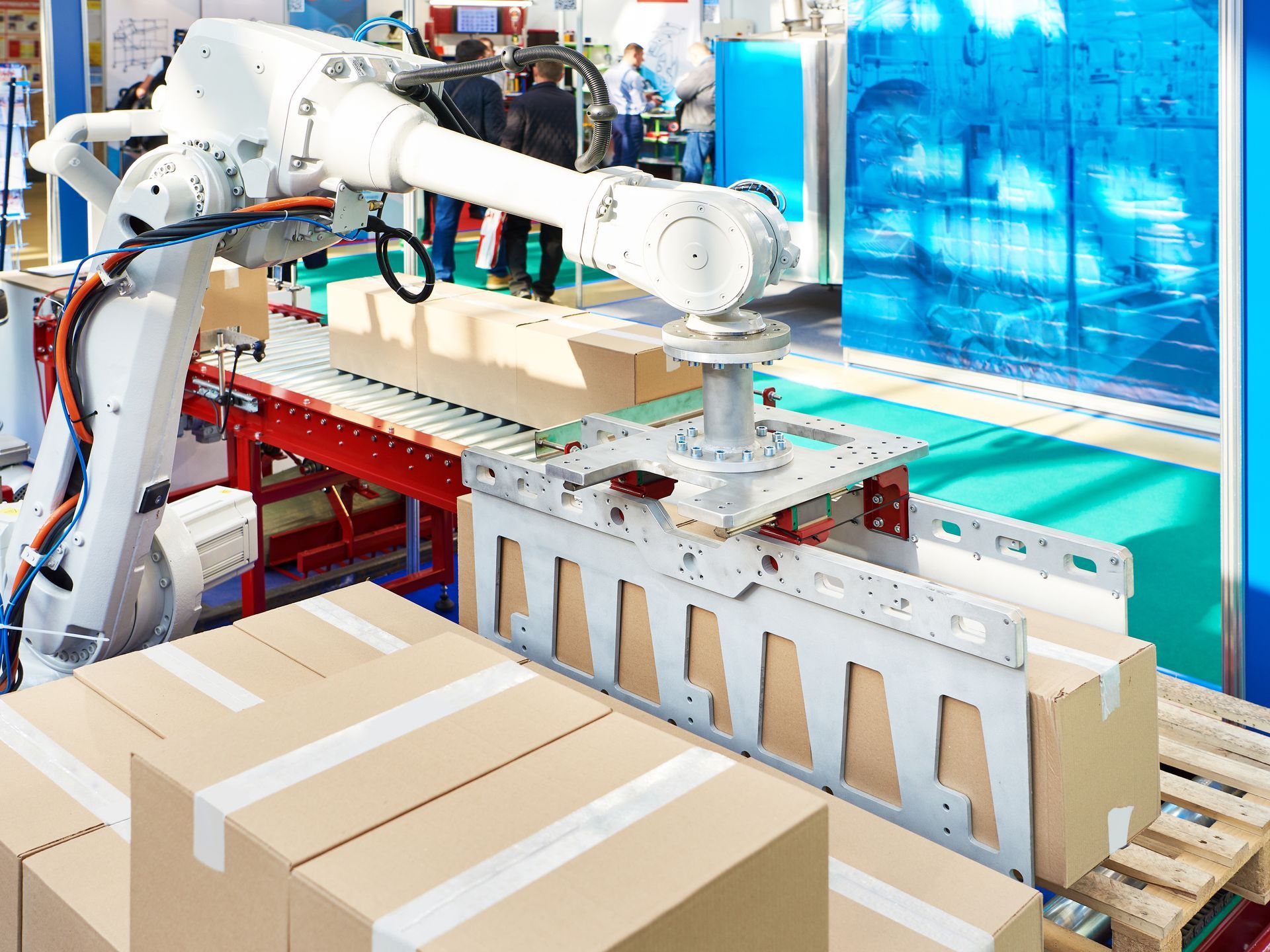 Ein Roboter trägt Kisten auf einem Förderband in einer Fabrik .