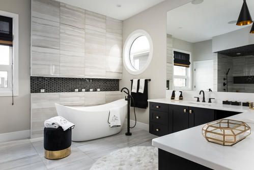 Luxurious modern bathroom with a soaking tub, black accents, and a round window.