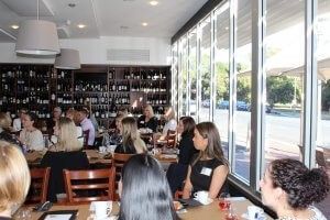 A group of people are sitting at tables in a restaurant.