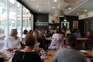 A group of people are sitting at tables in a restaurant.