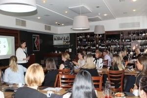 A woman is giving a presentation to a group of people in a restaurant.