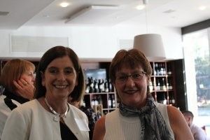Two women are posing for a picture together in a restaurant.