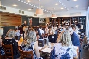A group of people are sitting at tables in a restaurant.