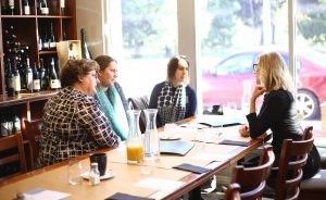 A group of women are sitting at a long table in a restaurant.