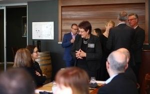 A group of people are standing around a table in a room.