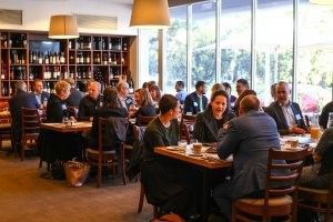 A group of people are sitting at tables in a restaurant.