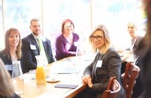 A group of people are sitting around a table having a meeting.