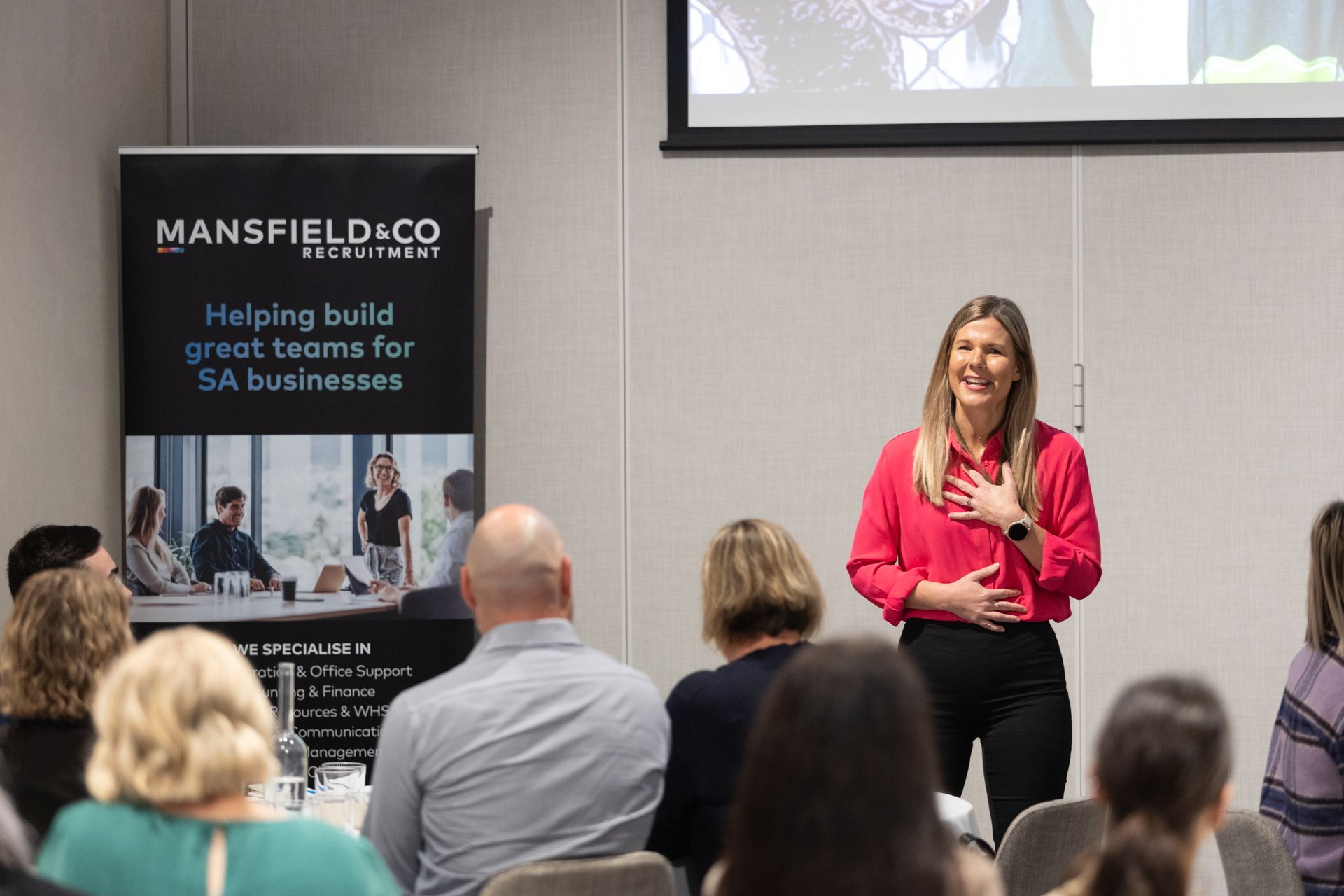 A woman is giving a presentation to a group of people.