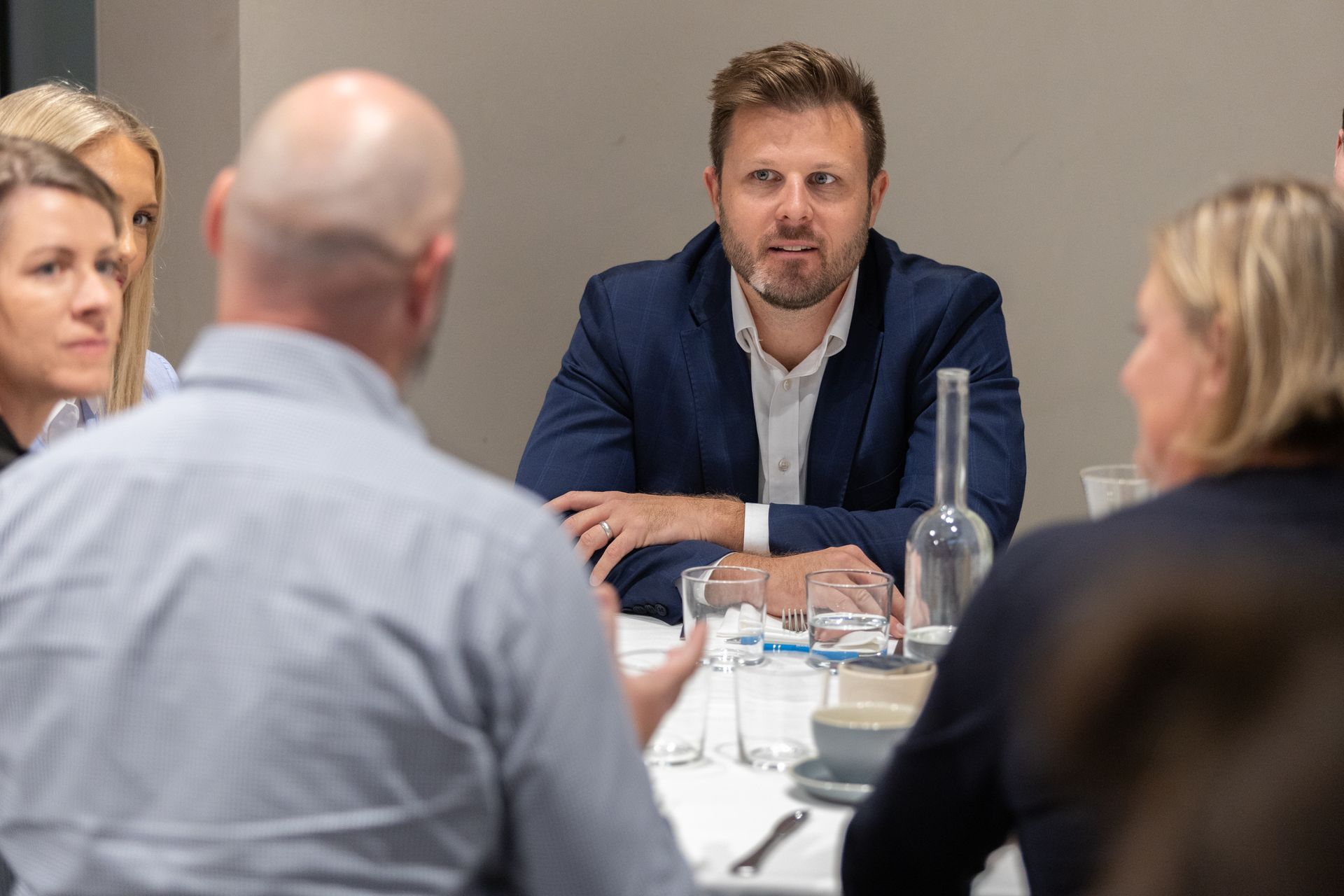 A group of people are sitting around a table having a meeting.