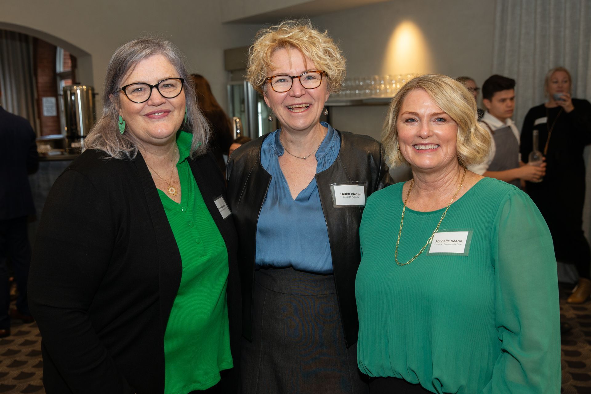 Three women are posing for a picture together in a room.