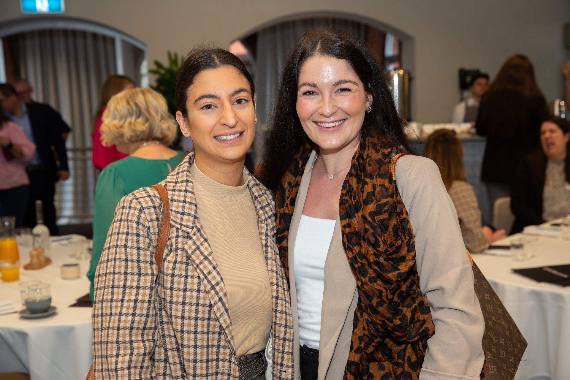 Two women are posing for a picture together in a room.