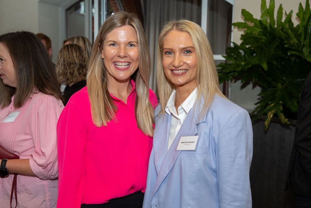 Two women are posing for a picture together at a party.