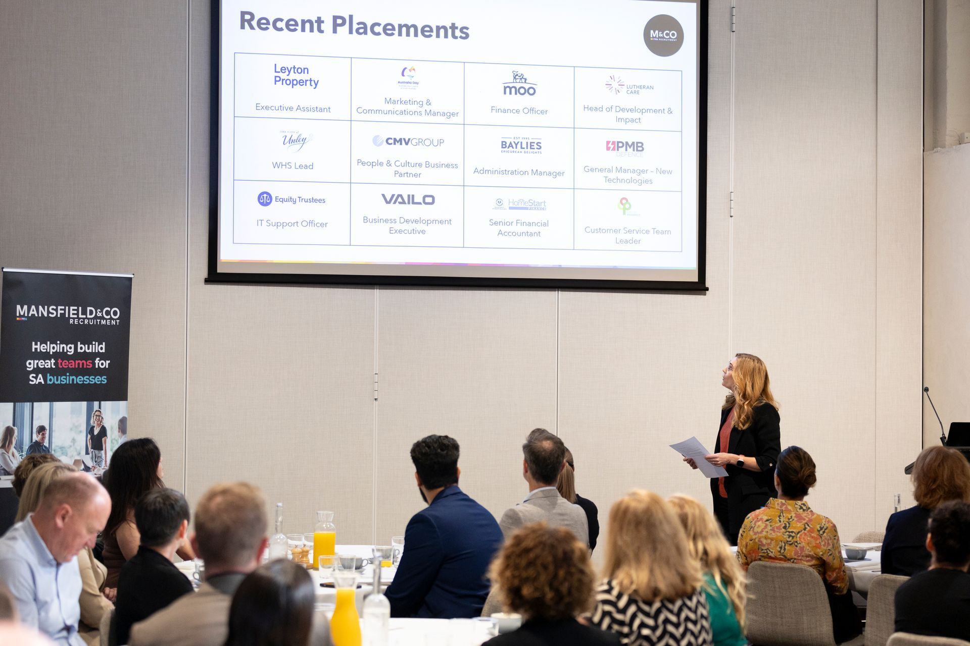 A woman is giving a presentation to a group of people.