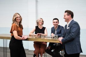 A group of people are sitting at a table talking to each other.