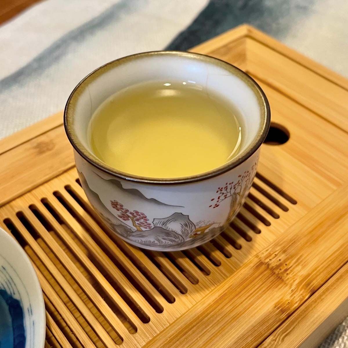 A cup of tea is sitting on a wooden tray