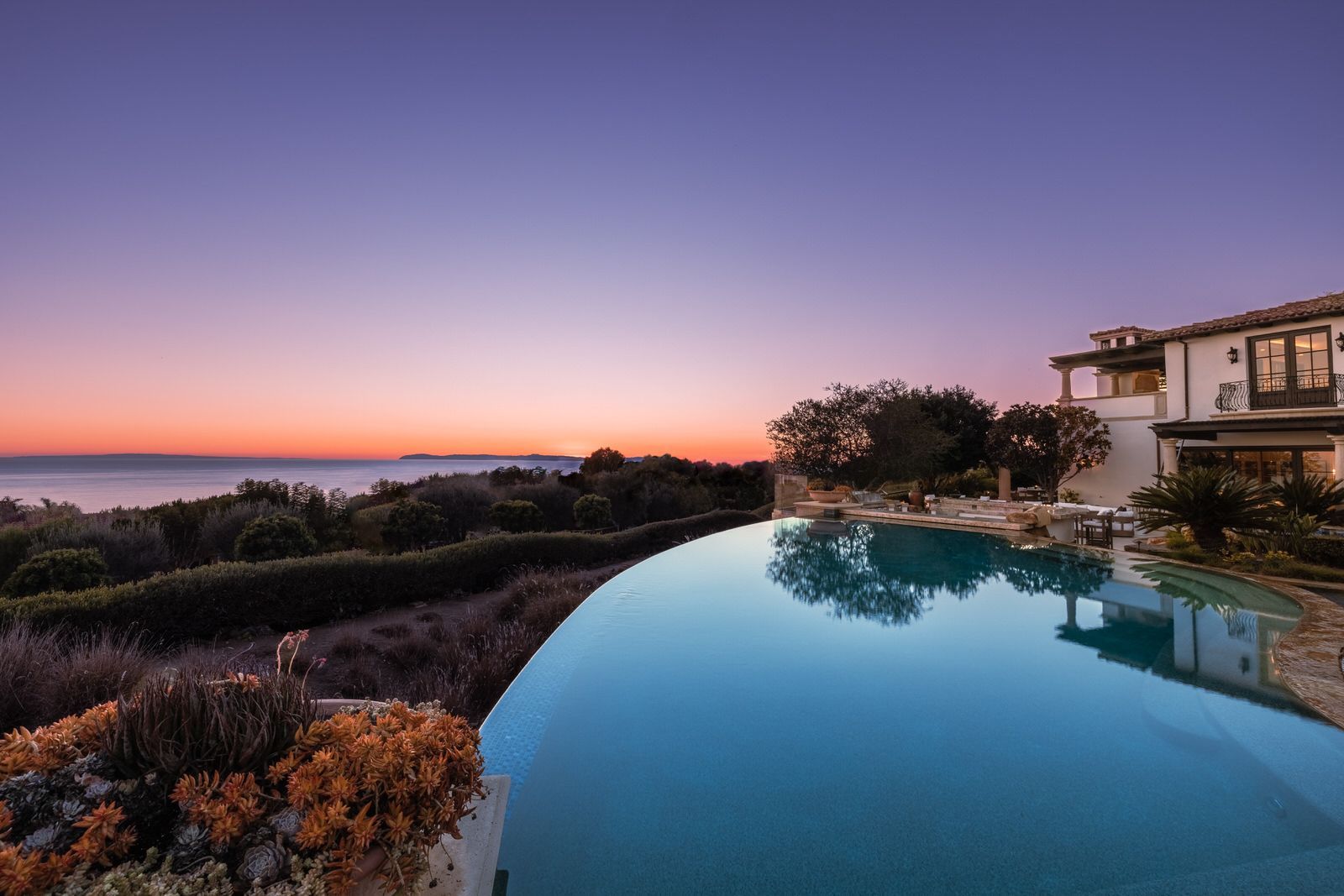 A large house with a swimming pool in front of it