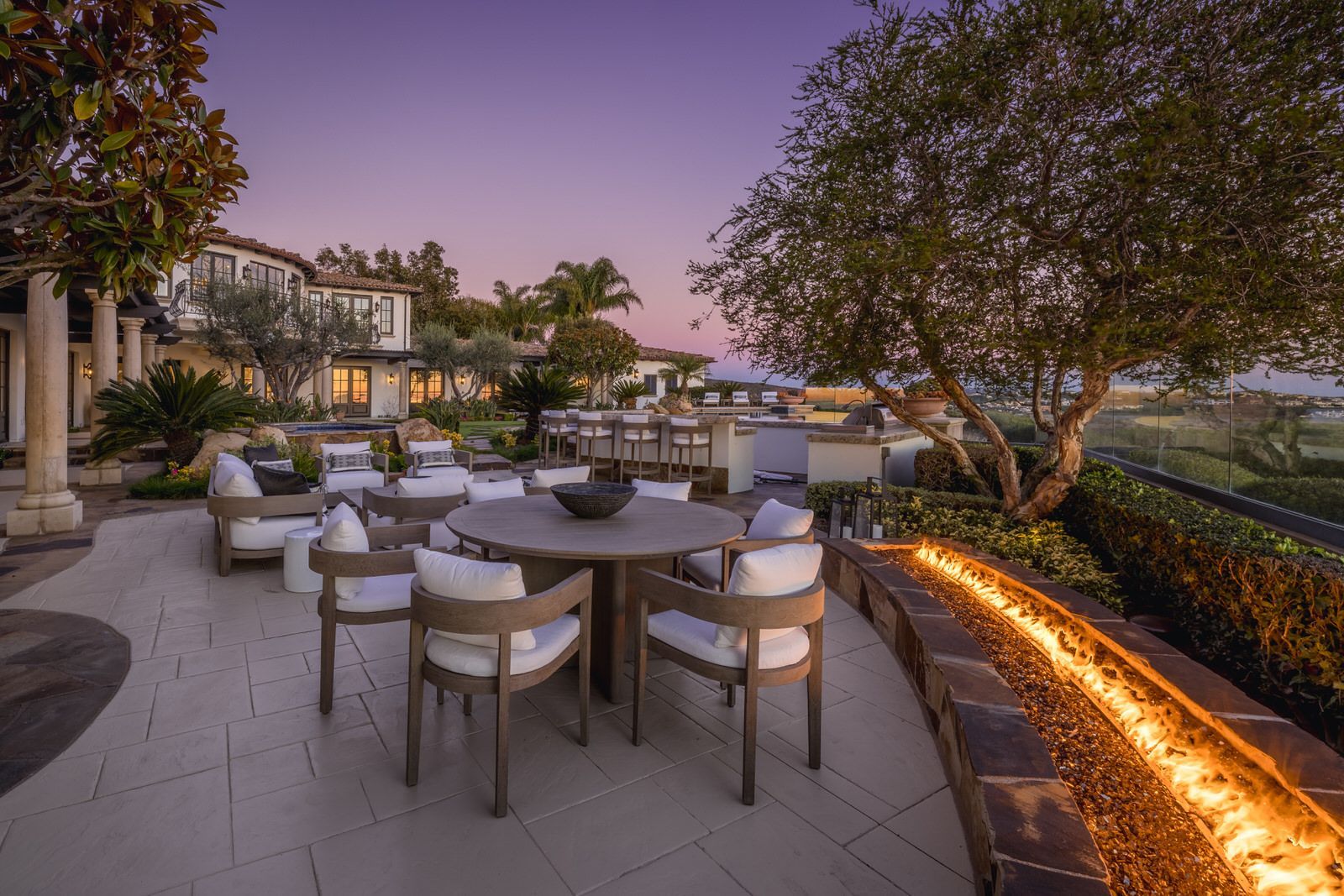 A patio with a table and chairs and a fire pit.