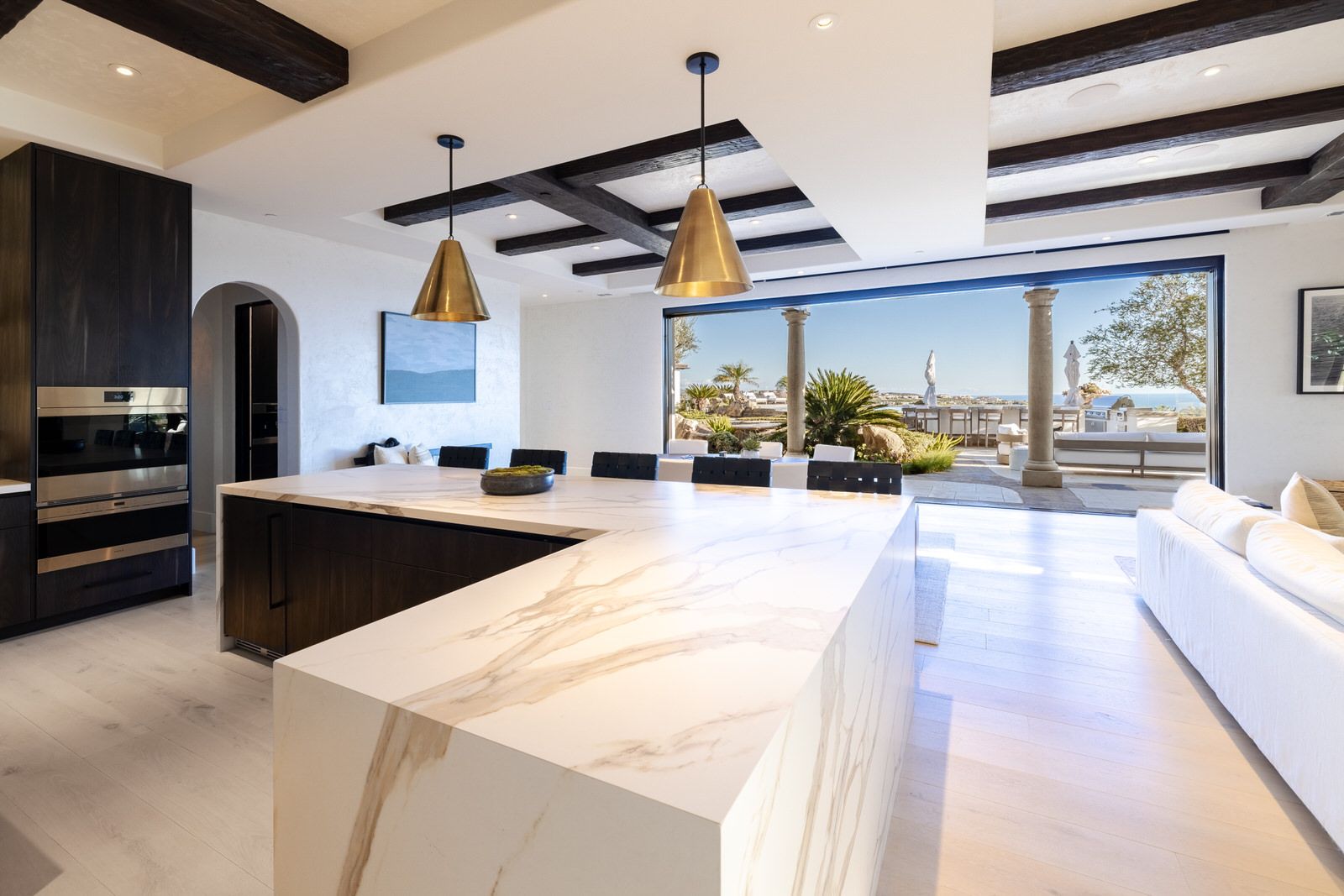 A kitchen with a large island and a sliding glass door.