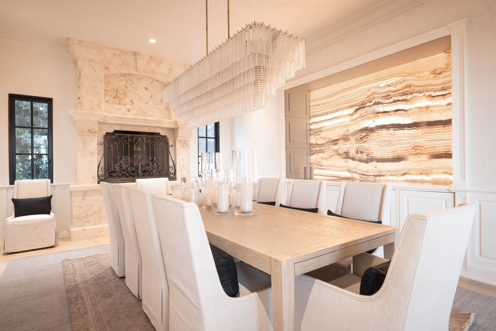A dining room with a long table and chairs and a fireplace.