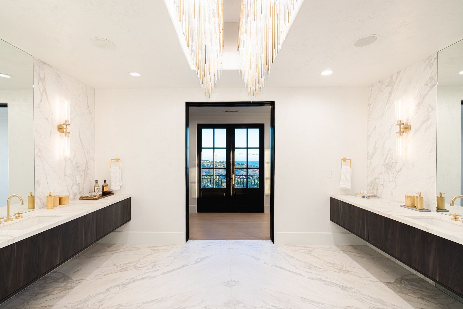A large bathroom with two sinks and a chandelier.