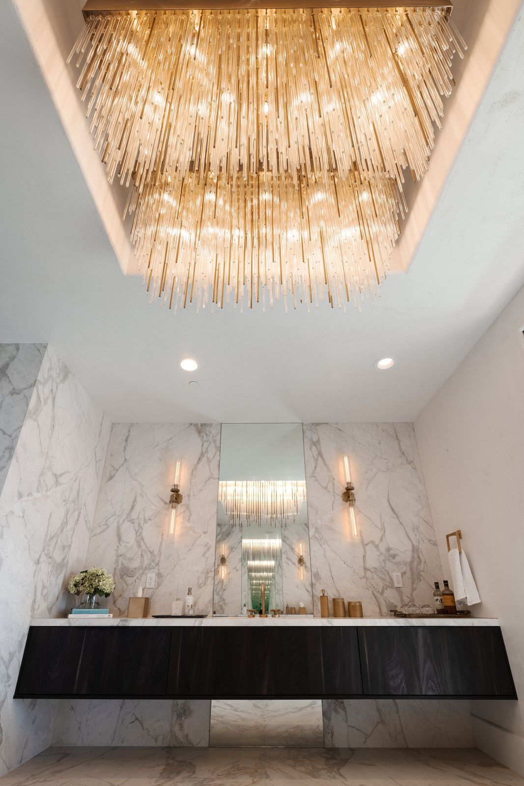 A bathroom with two sinks and a large chandelier hanging from the ceiling.