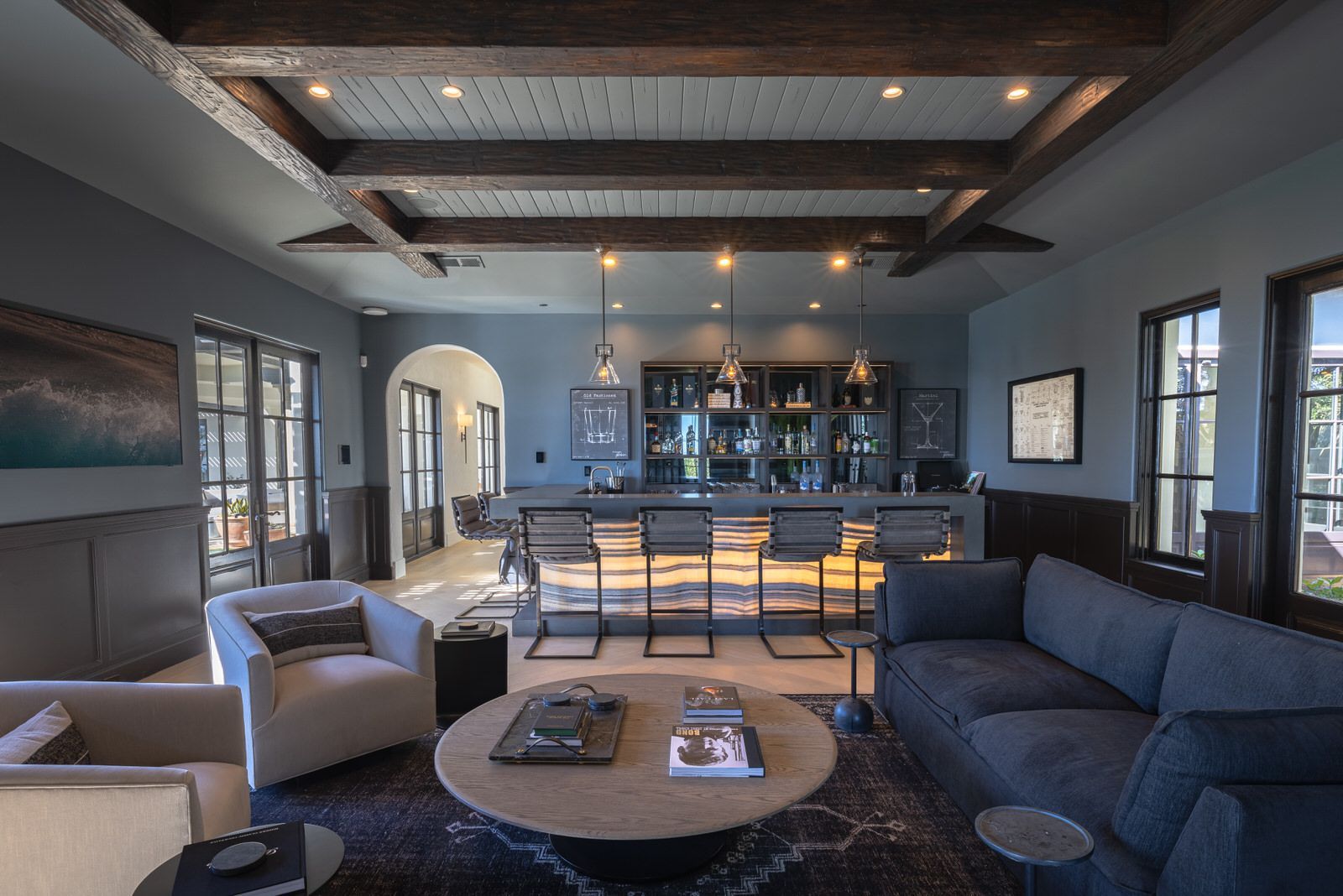 A living room with a couch and chairs and a bar