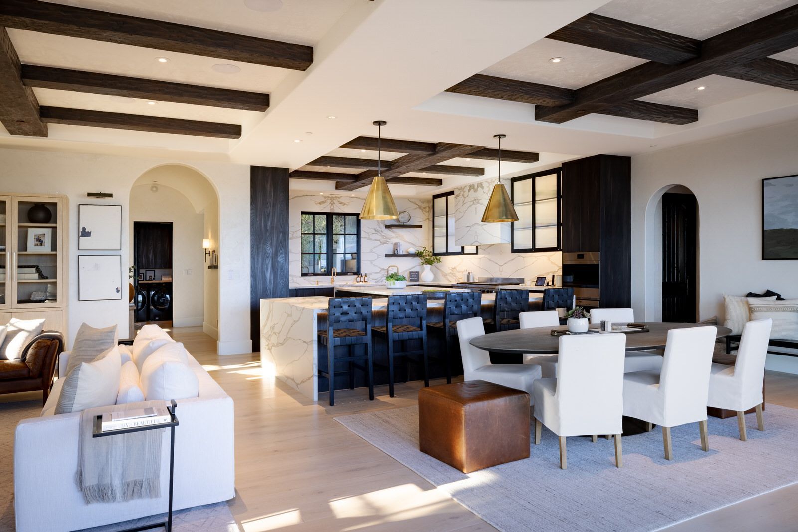 A large living room with a dining table and chairs and a kitchen.