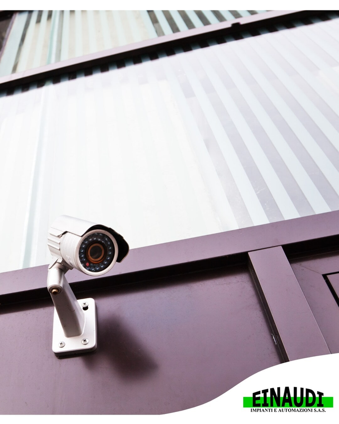 Telecamera di sicurezza montata su una parete sotto una facciata in lamiera ondulata