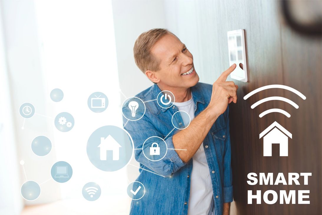 Un uomo sorride mentre regola un pannello di controllo per la casa intelligente, con sovrapposte le icone