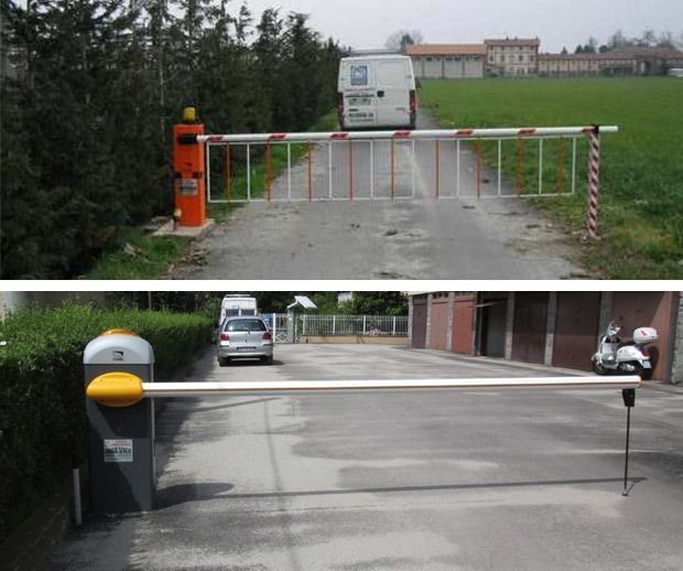 Due barriere di parcheggio lungo gli accessi carrabili: una a cancello rosso e bianco e una a braccio nero e giallo.