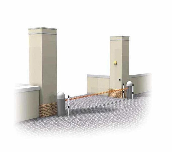 Ingresso carrabile con pilastri in mattoni e una sbarra di sicurezza arancione chiusa.