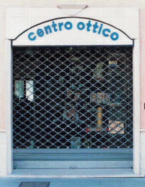 Vetrina di un negozio di occhiali chiuso, con insegna blu