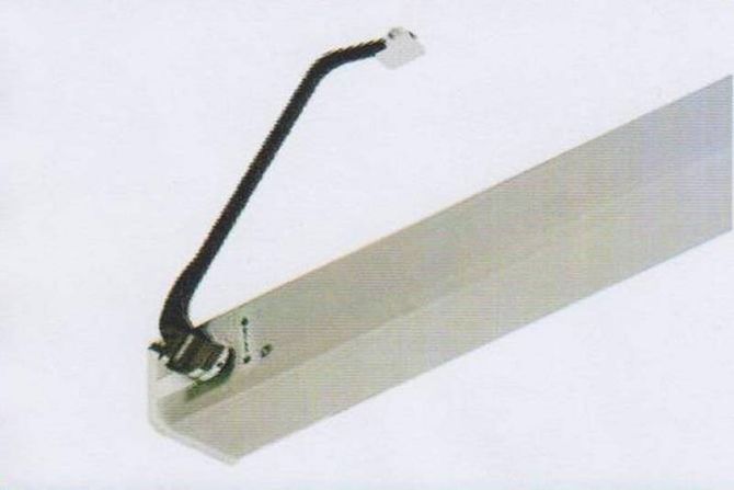 Braccio meccanico nero fissato a un apparecchio bianco montato a soffitto.