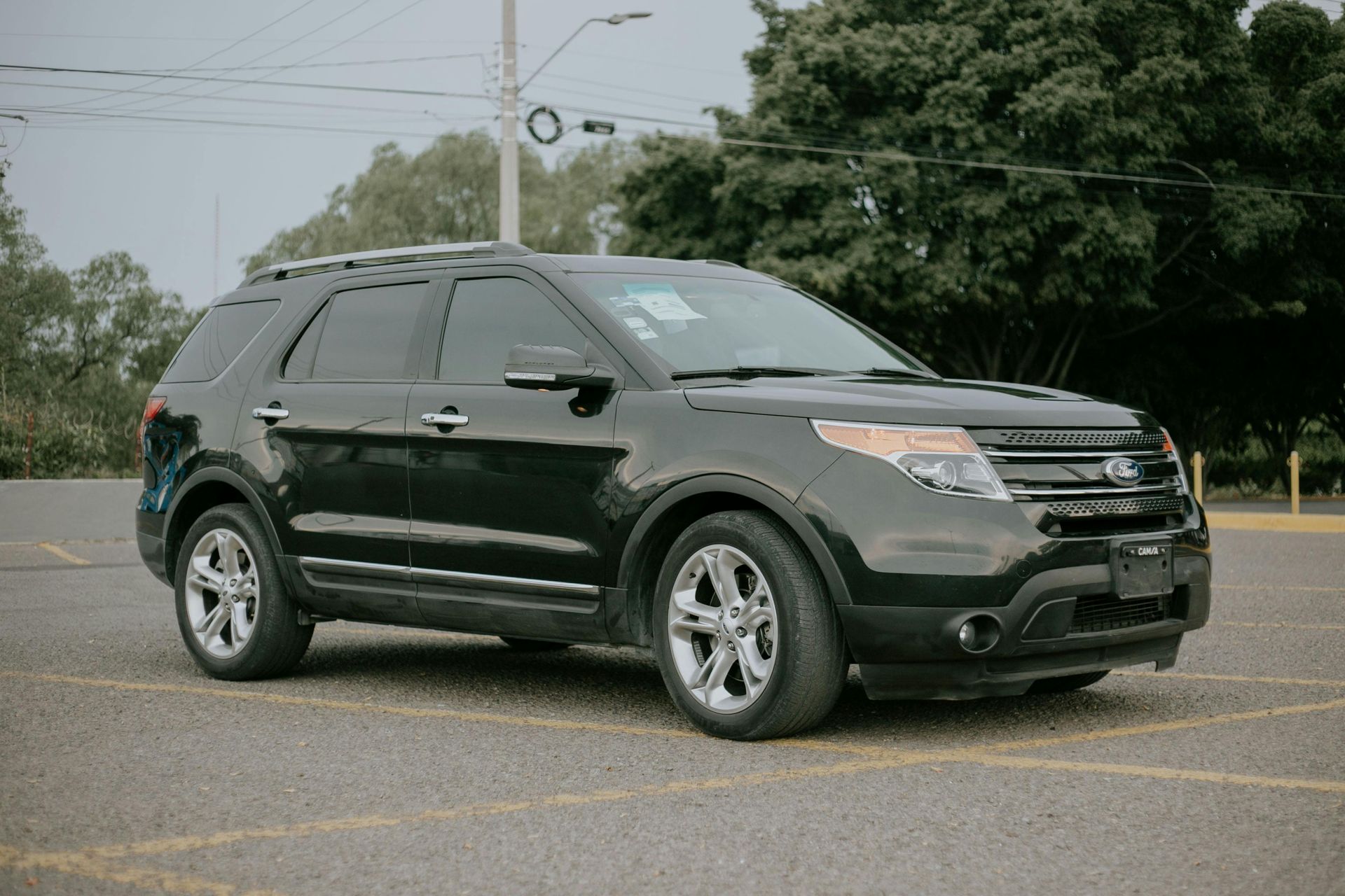 Black SUV parked in a lot on an overcast day, viewed from the front side