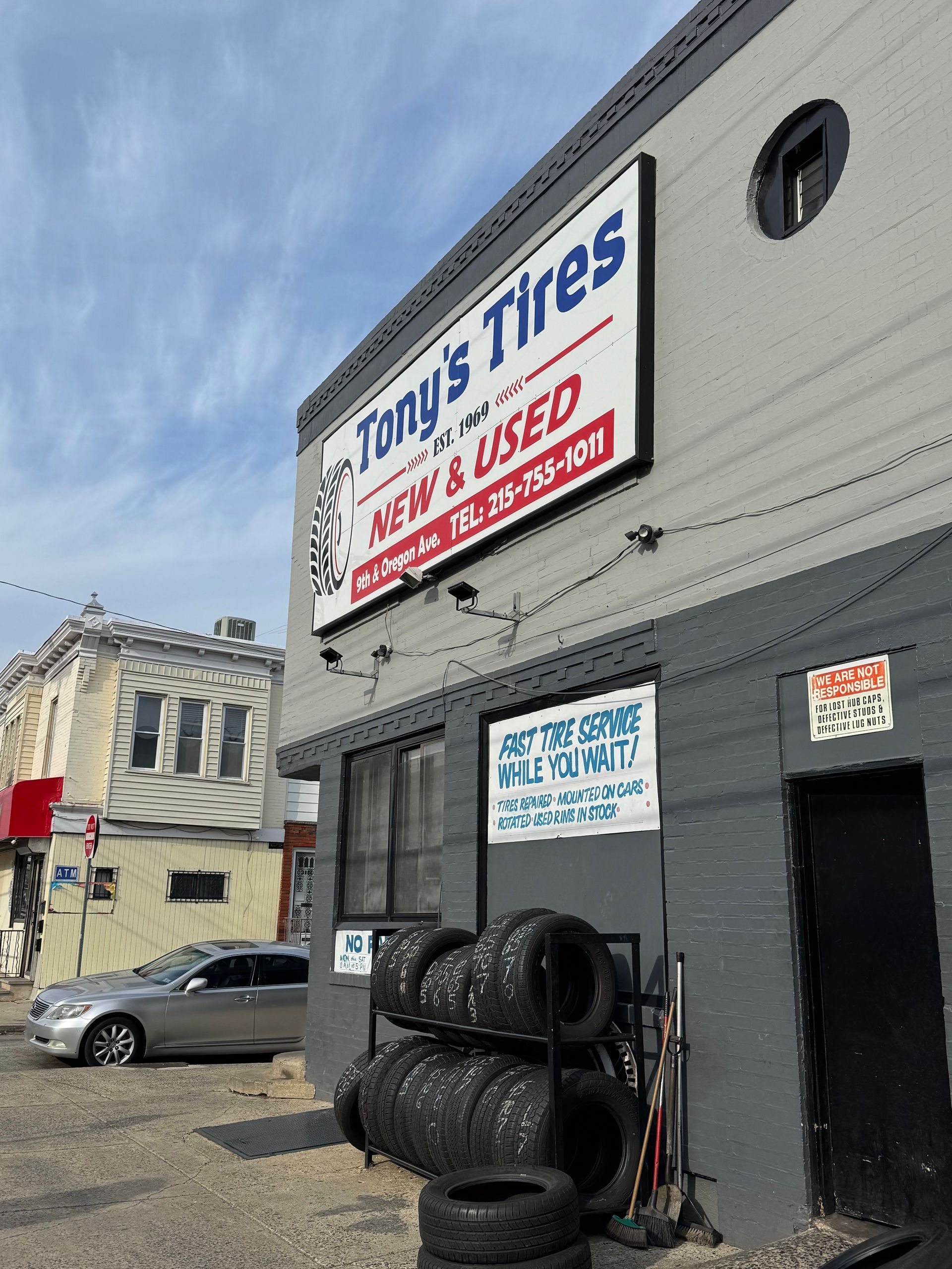Timmy Tyres shop exterior with stacked tires and blue sky above
