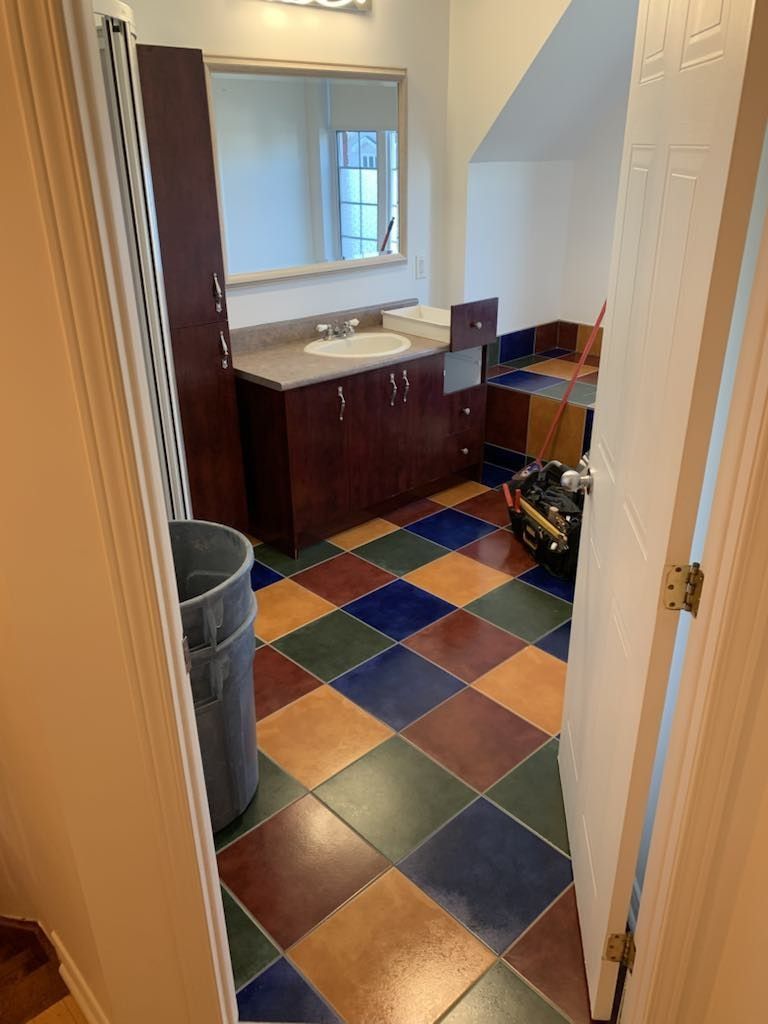 Une salle de bain avec un sol en carrelage à carreaux et deux lavabos.
