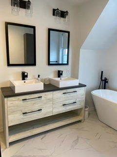 Une salle de bain avec deux lavabos et deux miroirs