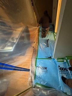 Un homme est agenouillé sur une feuille de plastique dans un couloir.