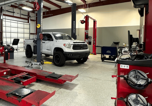 White SUV on a lift and red service equipment in the foreground