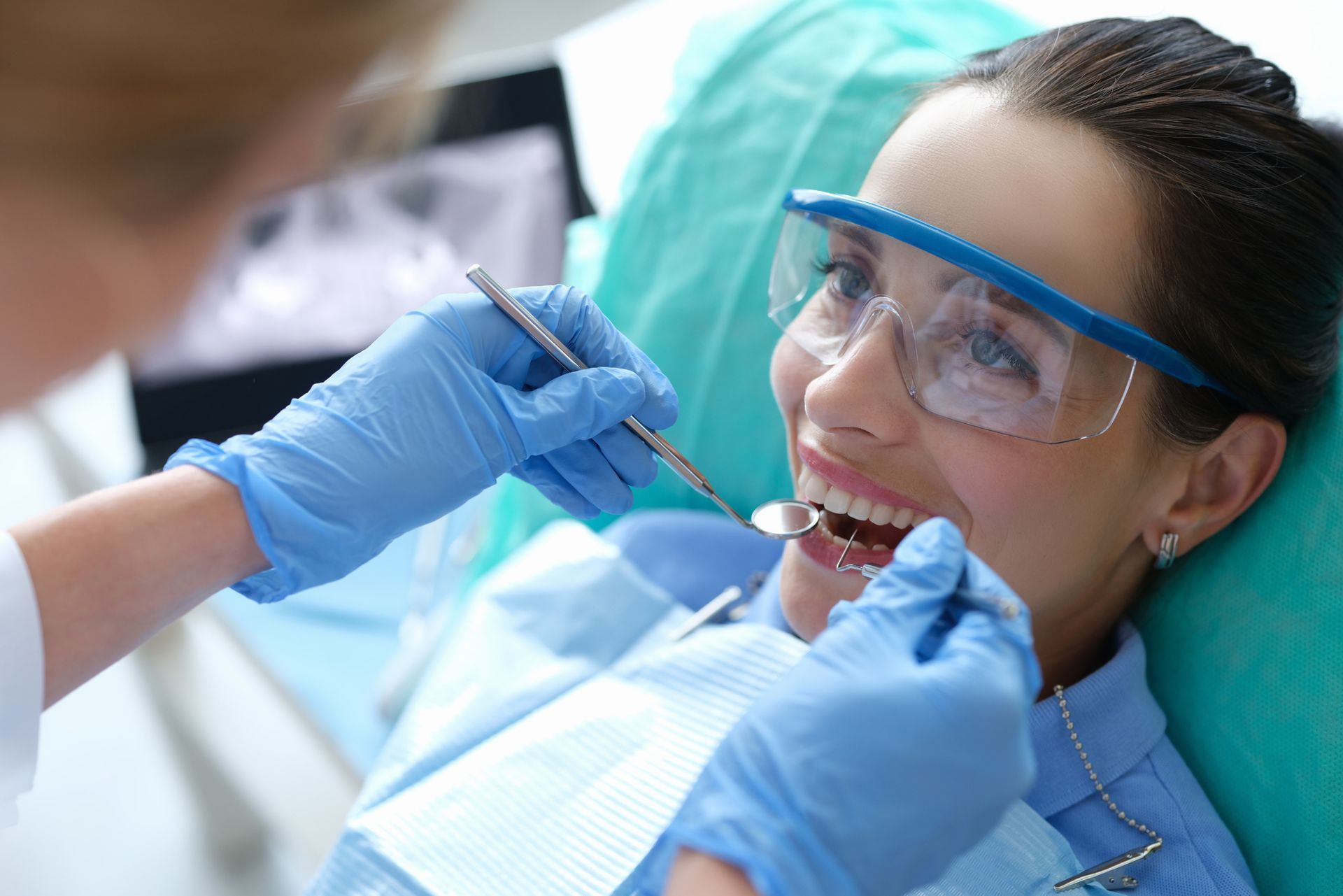 Doctor examining female patient's oral cavity with dental tools. Annual checkup concept.