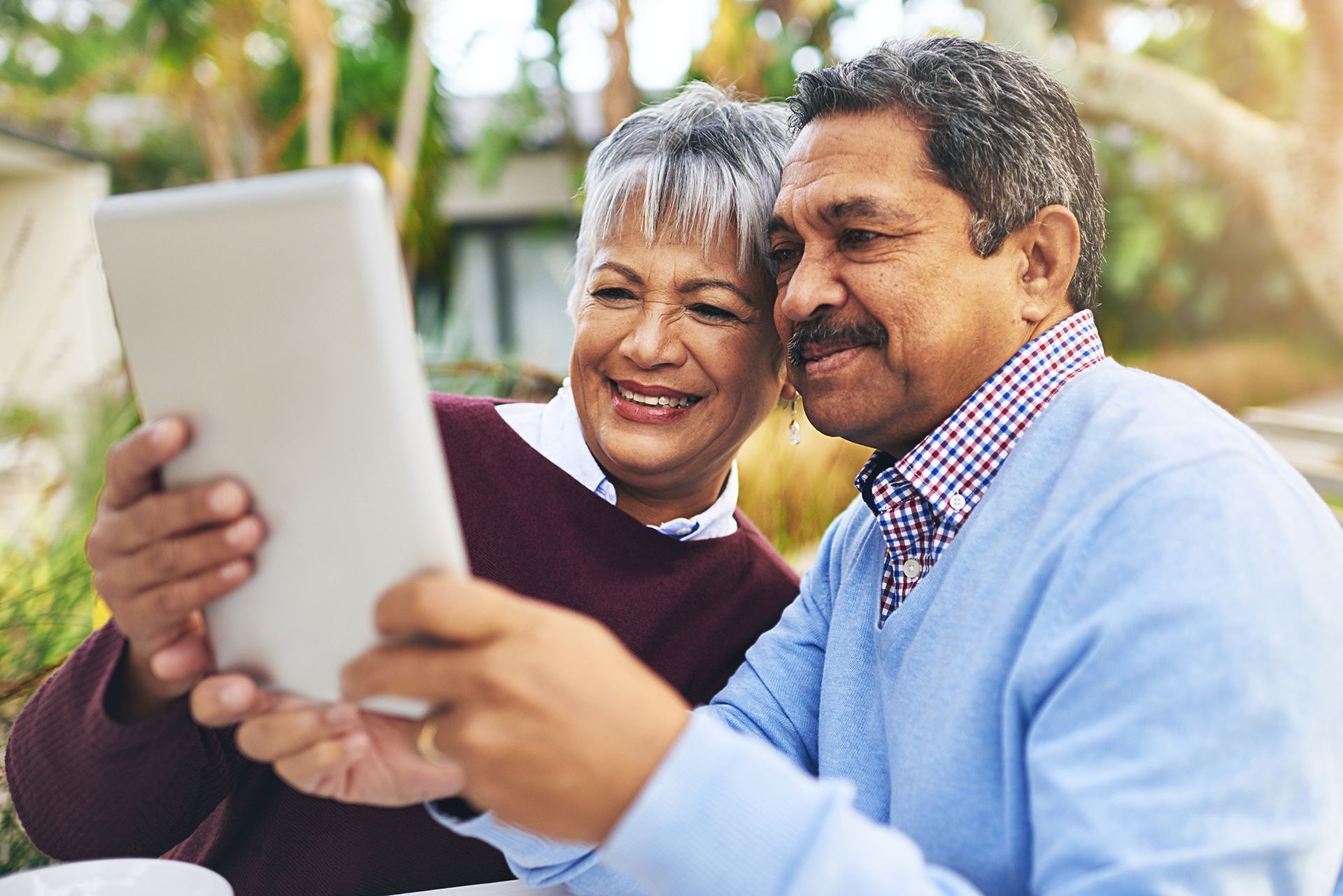 a man and a woman are looking at a tablet together .