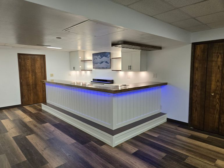 Modern kitchen with white brick backsplash, granite island, pendant light, and open shelves.