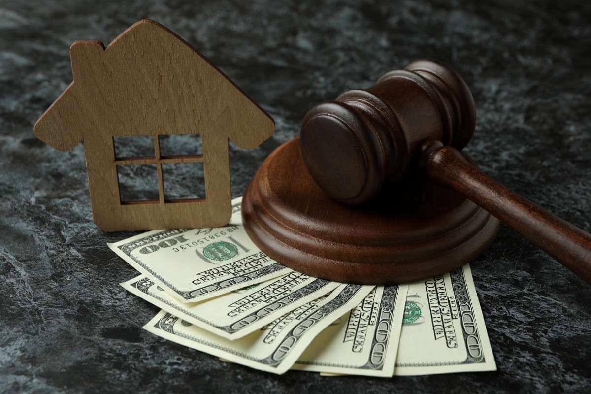House-shaped icon, gavel, and dollar bills symbolizing foreclosure or property law