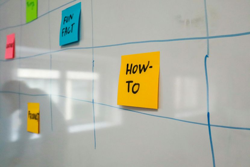 Sticky notes on a whiteboard, including yellow “How-To” and blue “Fun Fact” notes.