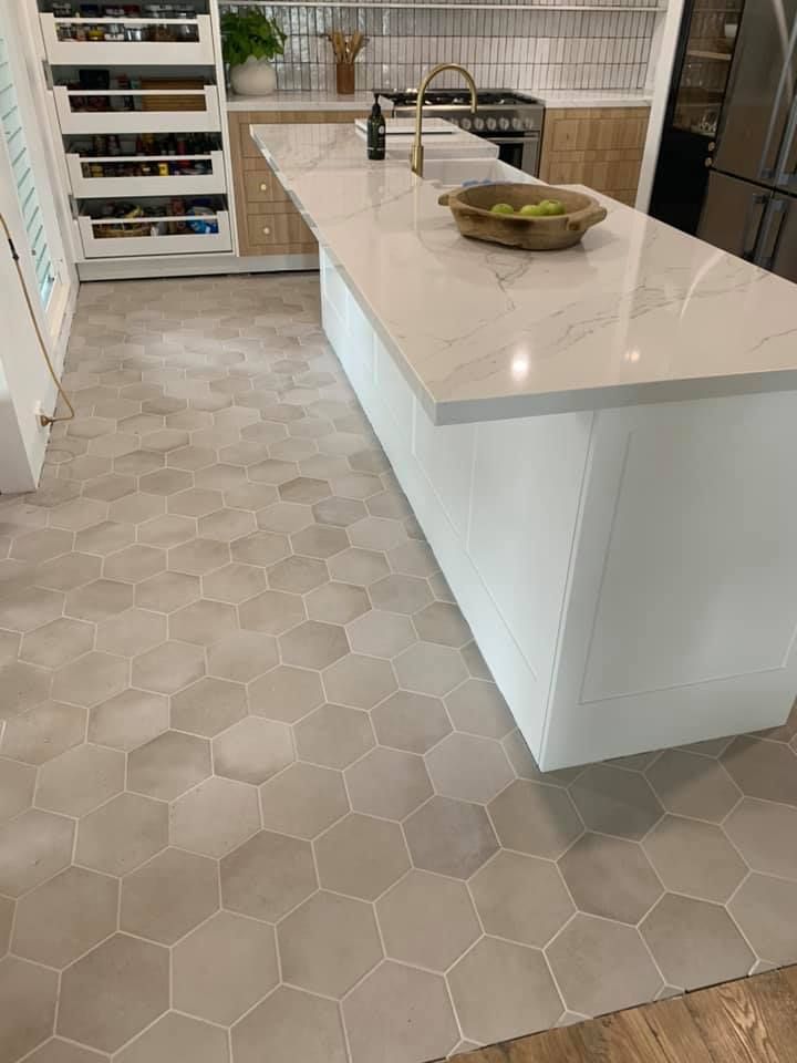 A Kitchen With a Large Island and a Marble Counter Top — ASpect Wall & Floor Tiling in Tuncurry, NSW