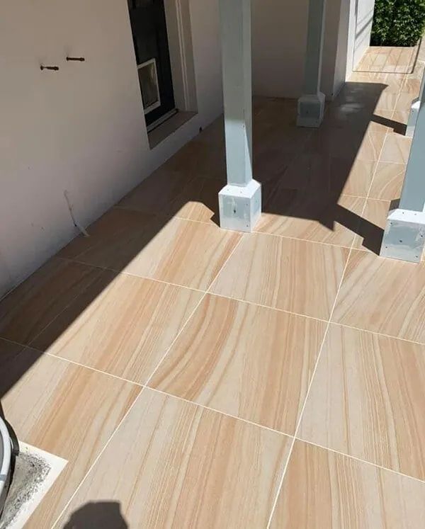 A Tiled Floor With a White Pillar in the Background — ASpect Wall & Floor Tiling in Charmhaven, NSW
