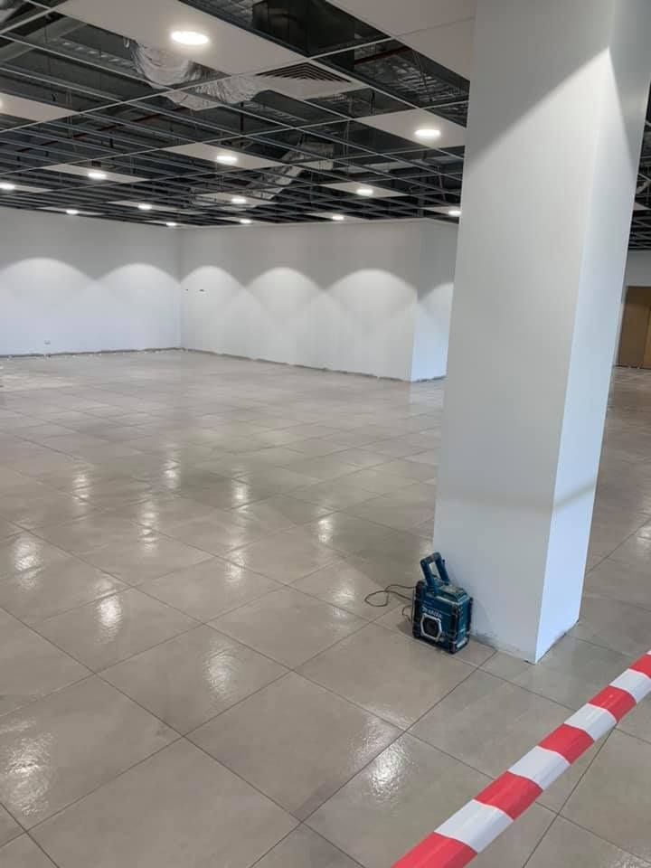 A Large Empty Room With a Red and White Tape on the Floor — ASpect Wall & Floor Tiling in Tuncurry, NSW