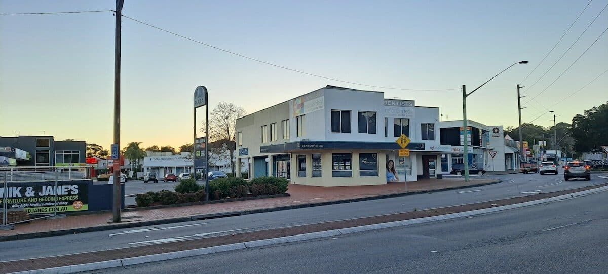 A White Building is Sitting on the Corner of a Street — ASpect Wall & Floor Tiling in Woy Woy, NSW
— ASpect Wall & Floor Tiling in Erina, NSW