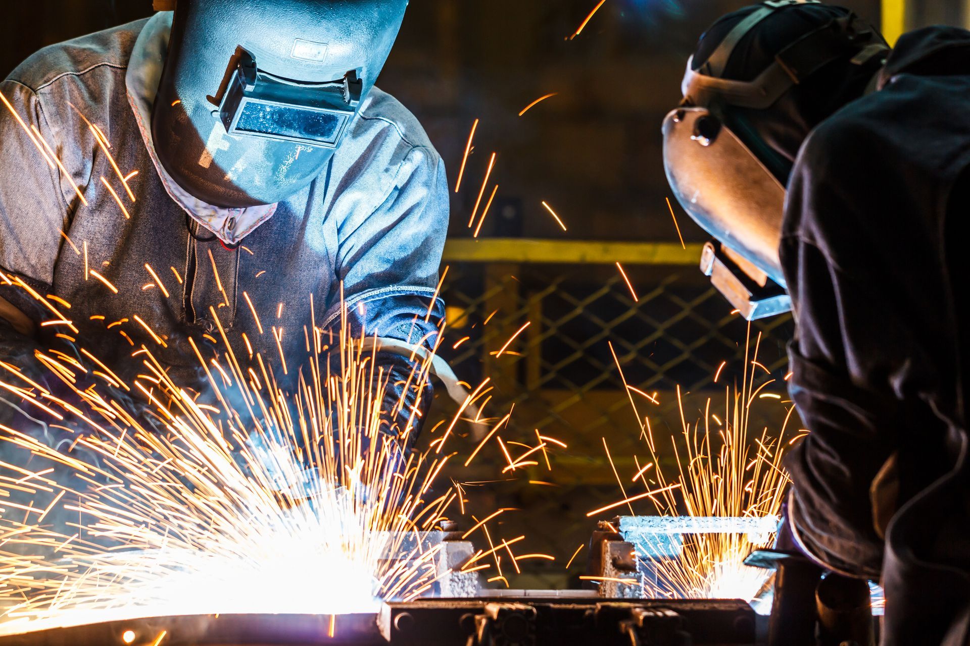 Two men are welding a piece of metal