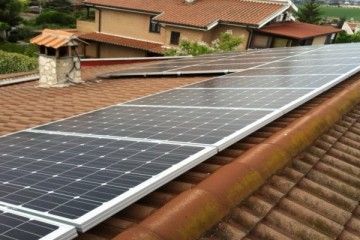 Pannelli solari installati su un tetto di tegole rosse in un quartiere residenziale